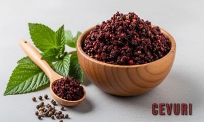 Cevurı spice blend in a wooden bowl with herbs and seeds around