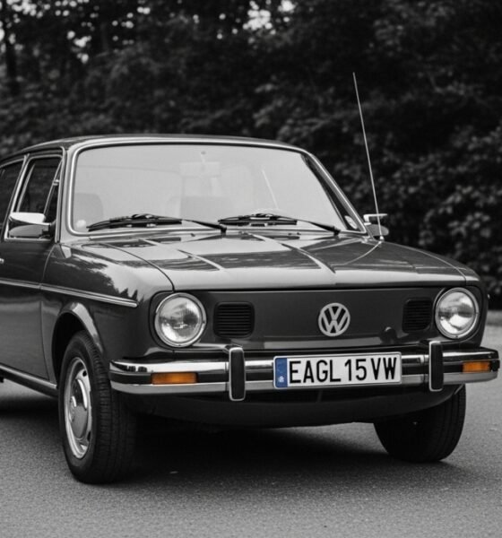 Vintage Eagle VW dealership sign displayed outside a classic Volkswagen showroom with Beetle and Golf models parked nearby.