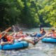 Tube Safari adventure on river with participants floating on inflatable tubes through scenic outdoor landscape